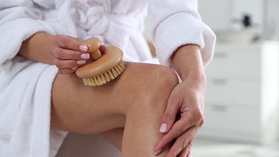 Žena skúša dry brushing, súčasť bodyshaping-u.
